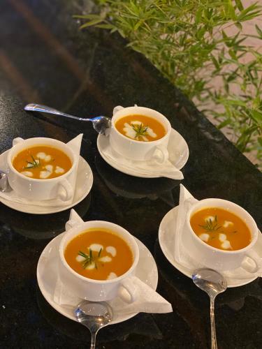 three bowls of soup on plates on a table at Lake Elementaita Manor in Gilgil
