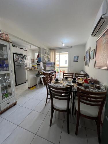 a kitchen and dining room with a table and chairs at Apartamento Próximo Ao Centro MultiUso São José in São José