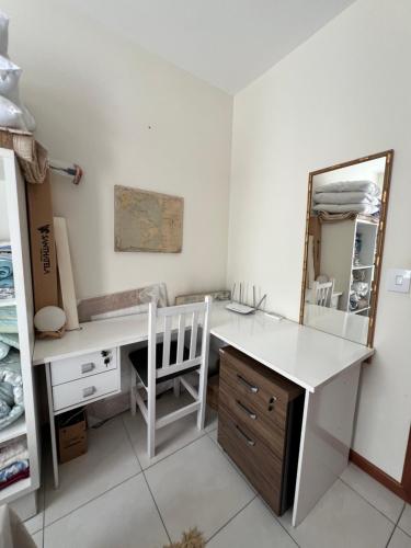 a white desk with a chair and a mirror at Apartamento Próximo Ao Centro MultiUso São José in São José