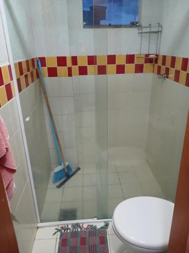 a bathroom with a shower with a toilet and a mop at Condomínio cesars park flats in Caldas Novas