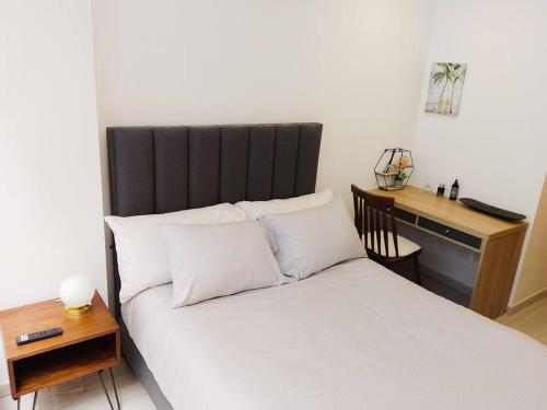 Cette chambre comprend un lit avec des oreillers blancs et un bureau. dans l'établissement Maravilloso loft en el centro de Chapinero 319, à Bogotá