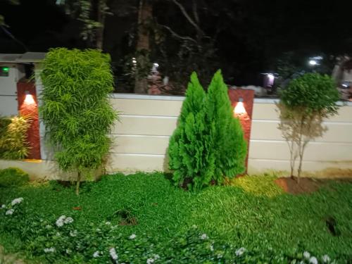 a garden with two trees and a fence at MARINA SUITES AIRPORT HOTEL in Cochin