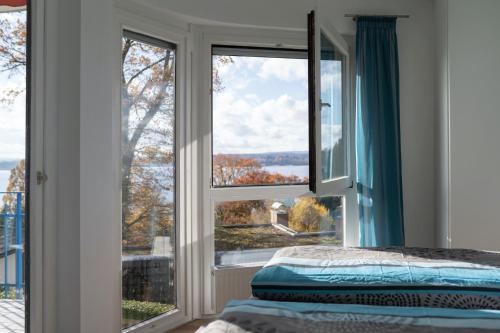 a bedroom with a window looking out at the water at Mainaublick in Uhldingen-Mühlhofen