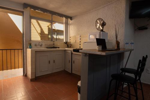 eine Küche mit weißen Schränken und einer Theke mit einer Mikrowelle in der Unterkunft Estudio12/ en Glorieta Chapalita in Guadalajara
