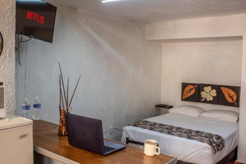 a bedroom with a bed and a laptop on a desk at Loft Privado en el Corazón de Chapalita 12 in Guadalajara