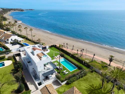 - une vue aérienne sur une maison et la plage dans l'établissement VACATION MARBELLA I Villa Imare Waterfront, Beachfront Villa, Rooftop Jacuzzi, Indoor Spa, à Estepona