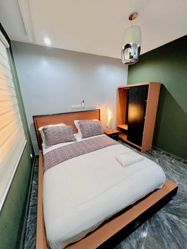 1 dormitorio con 1 cama grande y TV en The Jumeirah Guest Home, en Yaoundé