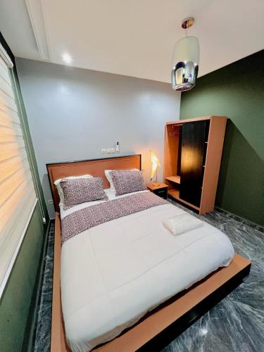 a bedroom with a large bed and a television at The Jumeirah Guest Home in Yaoundé