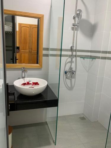 y baño con lavabo y ducha acristalada. en HA ANH PHAN THIẾT HOTEL en Phan Thiet