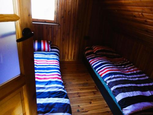 a couple of beds sitting in a room at House with a view of the lake, for 6 people in Łazy