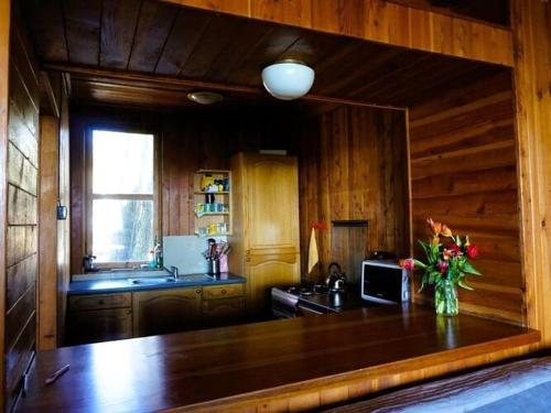 a kitchen with a table with a vase of flowers on it at House with a view of the lake, for 6 people in Łazy