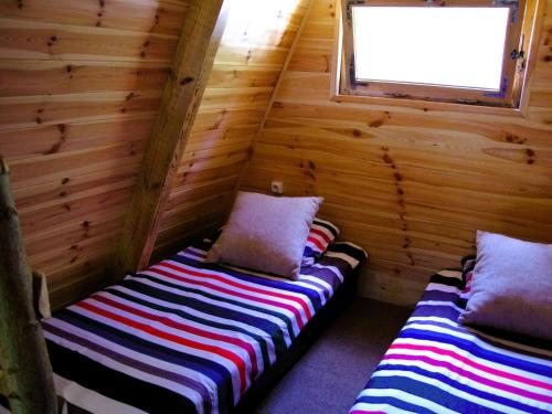 a room with two beds in a log cabin at Summer house for 4 people, close to the sea in Łazy