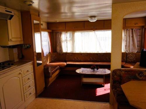 a kitchen with a couch and a table in a room at Dutch House near Lake Jamno and Beach in Łazy