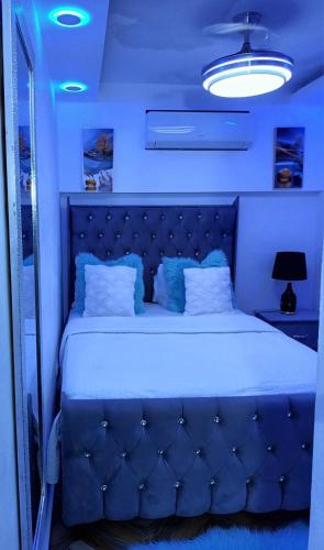 a blue bedroom with a large bed with a blue headboard at APARTAMENTOS DE 1 2 Y 3 HABITACIONEs in Santiago de los Caballeros