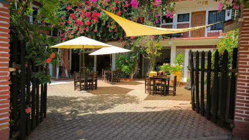 希伯萊特沙灘的住宿－Casa Bugambilias，户外庭院配有桌椅和遮阳伞。