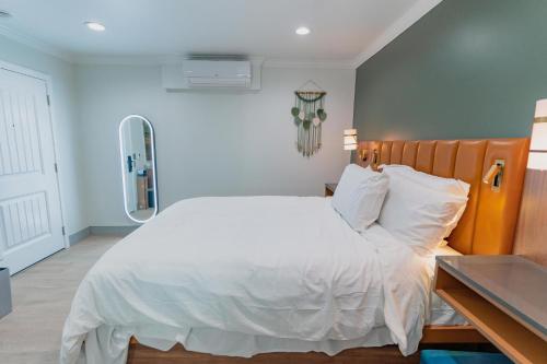 a bedroom with a white bed with a wooden headboard at Avanti in Santa Maria