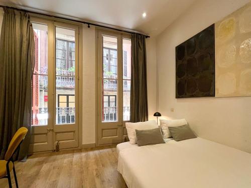 a bedroom with a bed and a large window at Stay U-nique Apartments Boters in Barcelona