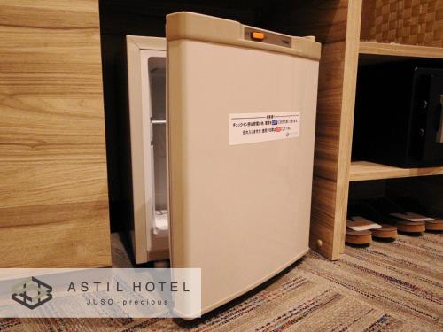 an ashley hotel refrigerator sitting in a room at Astil Hotel Juso Precious in Osaka