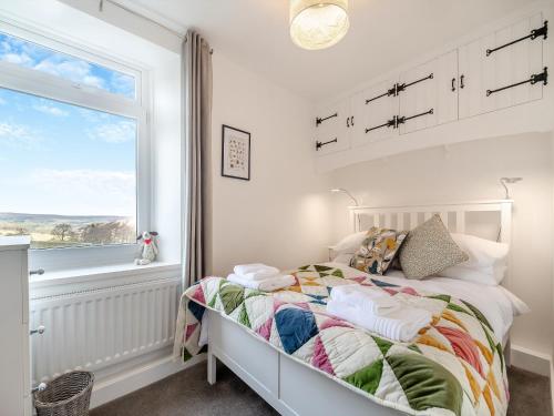 a white bedroom with a bed and a window at Little Gidding in Frosterley