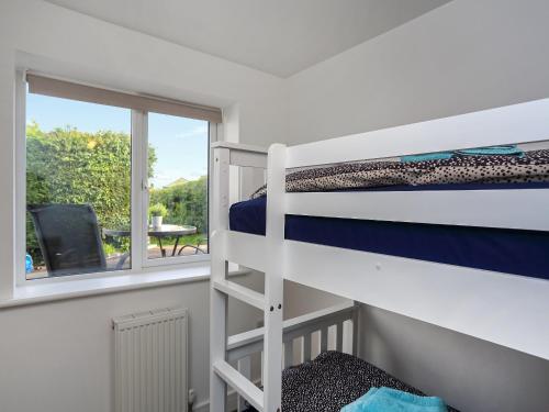 een slaapkamer met een stapelbed en een balkon met een tafel bij Hayfield in Paignton
