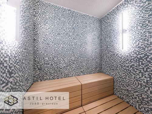 a room with a bed with a wall covered in wallpaper at Astil Hotel Juso Precious in Osaka