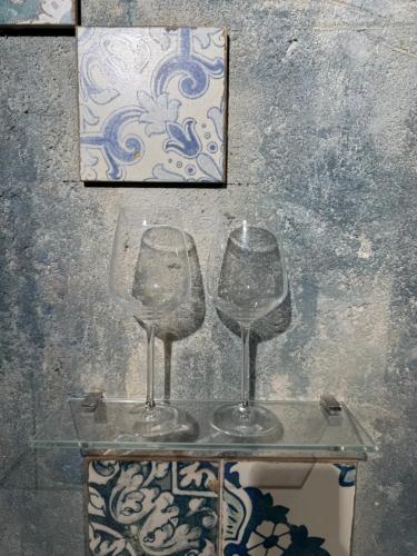 two empty wine glasses sitting on a glass table at Сity center Loft style Apartment in Tbilisi City