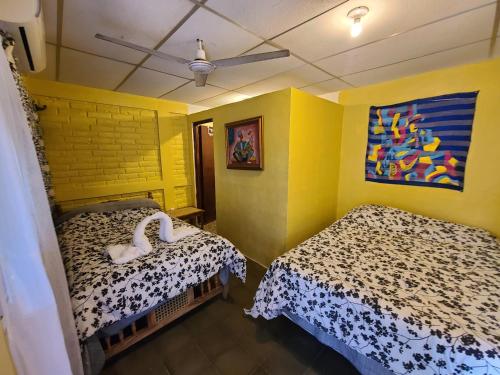 Alicia's healing and relaxing house في لا ليبرتاد: سريرين في غرفة بجدران صفراء