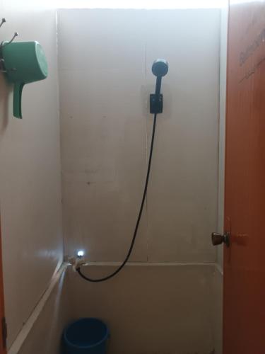 a shower with a hose attached to a wall at Tupi's Beachfront Home 2BR in Bacungan