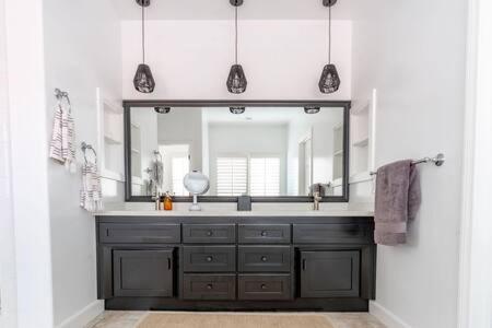 a bathroom with a sink and a large mirror at Carlsbad Dream House with Hot Tub Walk to Beach in Carlsbad