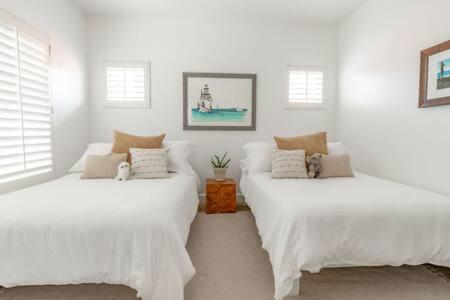 two beds in a room with white walls and windows at Carlsbad Dream House with Hot Tub Walk to Beach in Carlsbad
