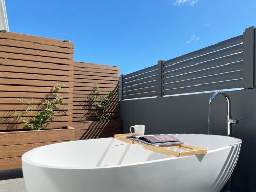 a bath tub in a bathroom with a fence at Little Island Apartments in Hobart