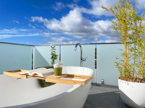 a bathroom with a bath tub on a balcony at Little Island Apartments in Hobart