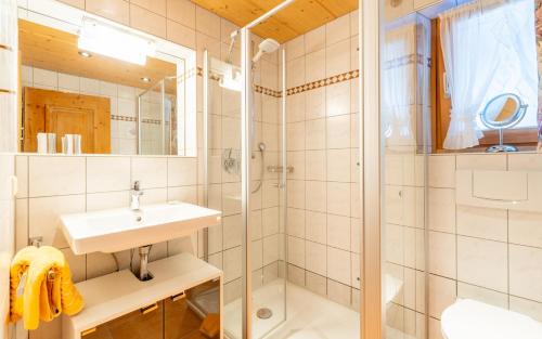 ein Bad mit einem Waschbecken und einer Dusche in der Unterkunft Gästehaus Hagen in Reit im Winkl