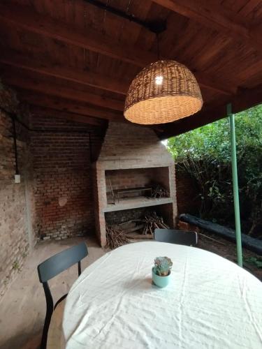 a table and chairs in a patio with a fireplace at CasaLins in Chascomús
