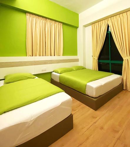 two beds in a room with green walls at Seanest Residence 贤巢民宿 18 "Owned by Amadel Residence" in Melaka