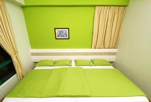 a green bedroom with a bed with green walls at Seanest Residence 贤巢民宿 18 "Owned by Amadel Residence" in Melaka