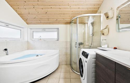 uma casa de banho com uma banheira, um lavatório e uma máquina de lavar roupa em 3 Bedroom Stunning Home In Give em Give