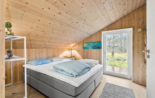 um quarto com uma cama num quarto com paredes de madeira em 3 Bedroom Stunning Home In Give em Give