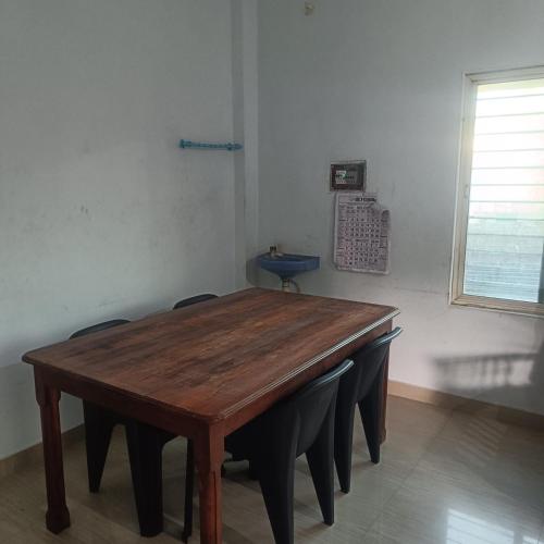a wooden table with chairs in a room with a window at Deep Apartment 