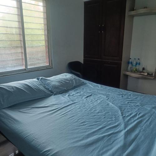 a bed in a bedroom with a blue sheet on it at Deep Apartment 