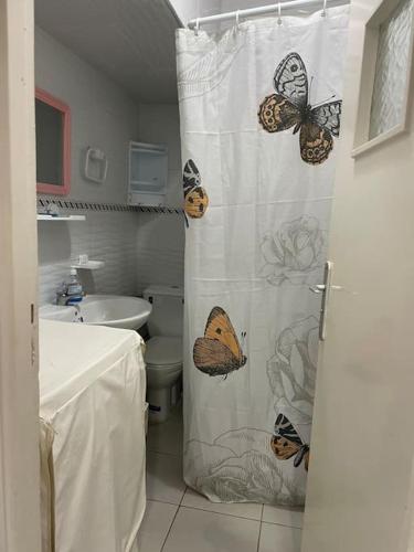 uma casa de banho com uma cortina de chuveiro com borboletas em Appartement à RABAT AGDAL em Rabat