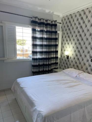 um quarto com uma cama branca e uma janela em Appartement à RABAT AGDAL em Rabat