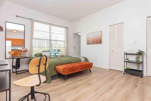 een slaapkamer met een bed, een tafel en een bureau bij Downtown 1-BR with Balcony - 5 Minutes to Wynwood in Miami