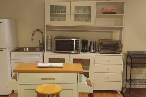 a kitchen with white cabinets and a sink and a microwave at Exquisite 1 Bedroom, 1 Full Bath Apartment in Upper Marlboro