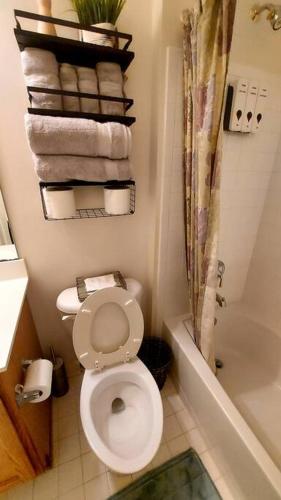 a bathroom with a toilet and a tub and towels at Exquisite 1 Bedroom, 1 Full Bath Apartment in Upper Marlboro