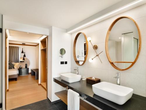 a bathroom with two sinks and a mirror at Le Tahiti by Pearl Resorts in Papeete