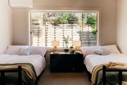 2 Betten in einem Zimmer mit Fenster in der Unterkunft Sorrento Lodge in Sorrento