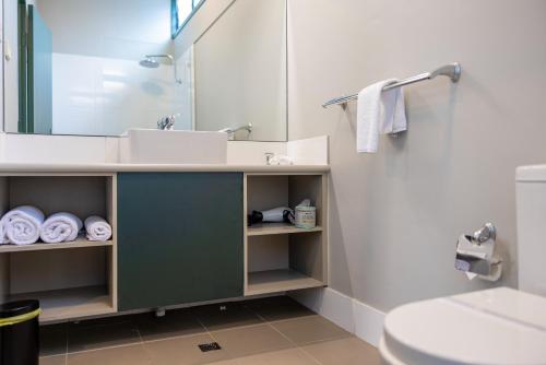a bathroom with a sink and a toilet and a mirror at Everton Park Hotel in Brisbane