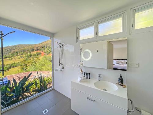 baño con lavabo y ventana grande en Elouera Retreat en Mount View
