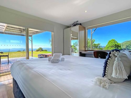 1 dormitorio con 1 cama grande y vistas al océano en Elouera Retreat en Mount View